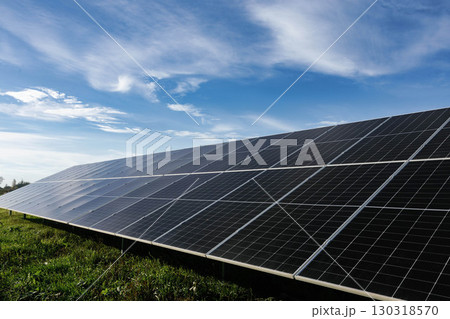 Solar panels absorbing sunlight under a cloudy blue sky 130318570