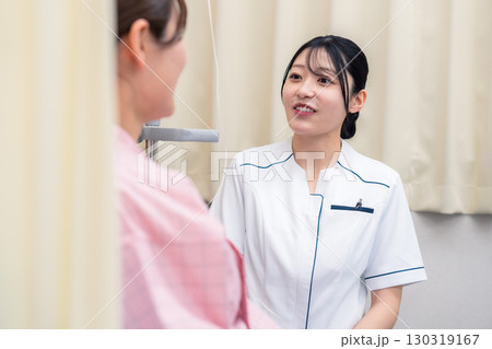 入院中の患者と話す医療従事者の女性 入院中の患者と話す医療従事者の女性 130319167