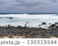 A view of the rugged coastline of La Graciosa, Lanzarote, with the waves crashing against the volcanic rocks on the beach. 130319344