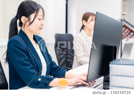 オフィスでデスクワークをする若い女性 130319720