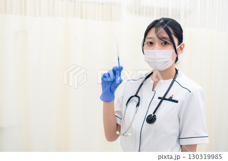 注射器を持つ若い女性の医療従事者 130319985