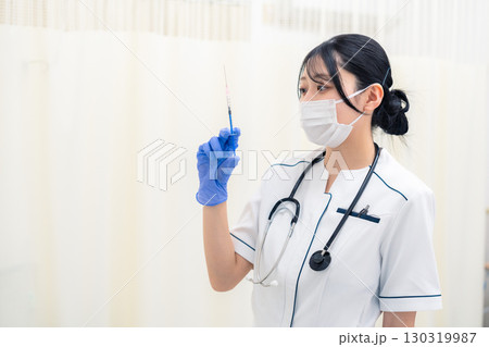 注射器を持つ若い女性の医療従事者 注射器を持つ若い女性の医療従事者 130319987