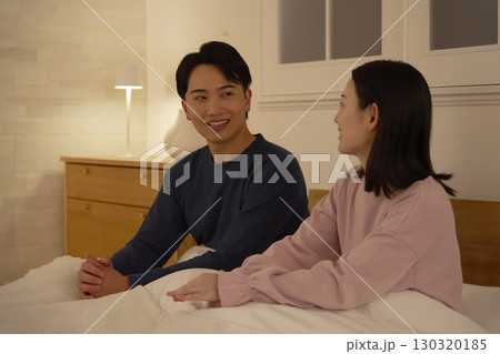 ベッドの上で会話する夫婦 ベッドの上で会話する夫婦 130320185