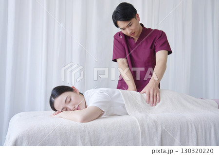 女性 マッサージ師による背中のマッサージ 女性 マッサージ師による背中のマッサージ 130320220