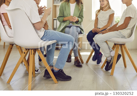 Woman psychologist conducts a mental health lesson with a group of school children. Woman psychologist conducts a mental health lesson with a group of school children. 130320252