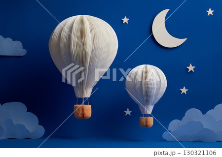 Two white paper hot air balloons float against dark blue night sky with crescent moon, stars, and clouds, creating whimsical scene Two white paper hot air balloons float against dark blue night sky with crescent moon, stars, and clouds, creating whimsical scene 130321106