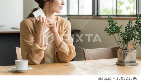 カフェでコーヒーを飲みながら読書をする女性 130321590