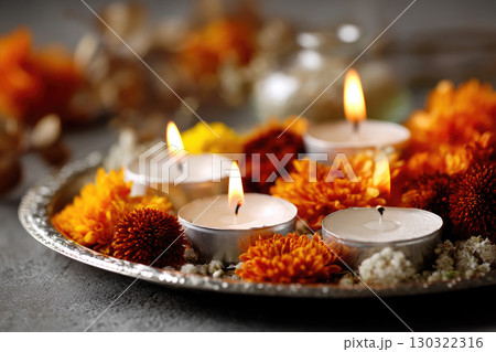 candles and autumnal flowers Closeup of beautiful autumnal flowers and white small candles with flame on silver tray, Diwali concept candles and autumnal flowers Closeup of beautiful autumnal flowers and white small candles with flame on silver tray, Diwali concept 130322316