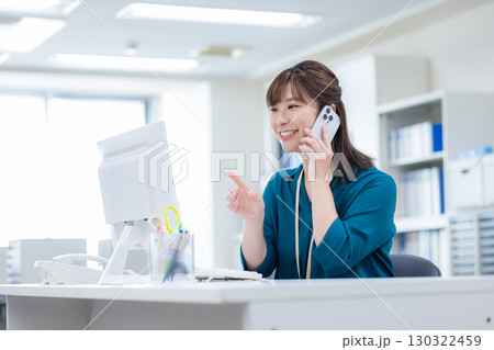 ビジネス　スマホで電話をしている女性 130322459