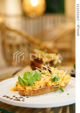 Delicious healthy breakfast plate, sourdough sandwich with scrambled eggs and avocado. 130322533