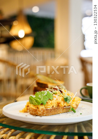 Delicious healthy breakfast plate, sourdough sandwich with scrambled eggs and avocado. 130322534