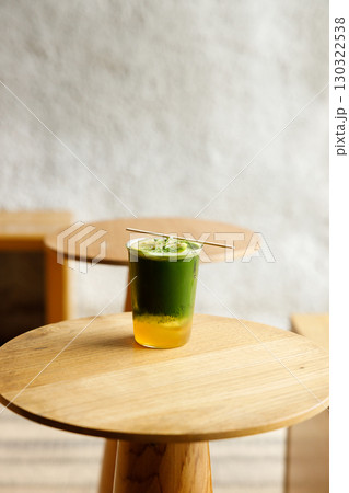 Creation beverage of fresh matcha tea, green tea and lemon juice on wooden table by the window. 130322538