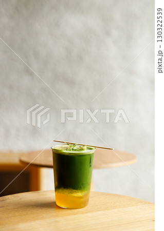 Creation beverage of fresh matcha tea, green tea and lemon juice on wooden table by the window. 130322539