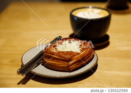 Cup of hot milk latte coffee and Mushroom danish pastry on table. Cup of hot milk latte coffee and Mushroom danish pastry on table. 130322560