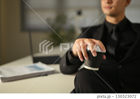 Close up of businessman in black suit holding takeaway coffee cup during work break 130323072