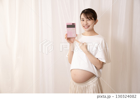 ピンクの電卓を持つ妊娠8ヶ月の女性 ピンクの電卓を持つ妊娠8ヶ月の女性 130324082