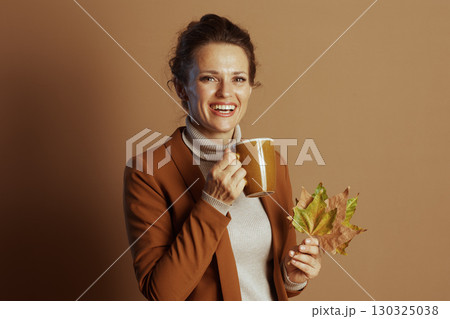 Cheerful Businesswoman with Autumn Leaves and Warm Mug Cheerful Businesswoman with Autumn Leaves and Warm Mug 130325038