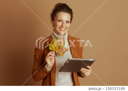 Cheerful Professional with Autumn Leaves and Tablet Cheerful Professional with Autumn Leaves and Tablet 130325189