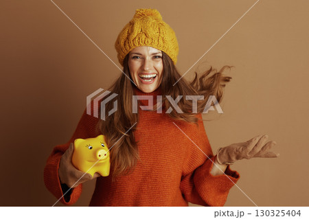 Laughing Woman with Piggy Bank and Beanie 130325404