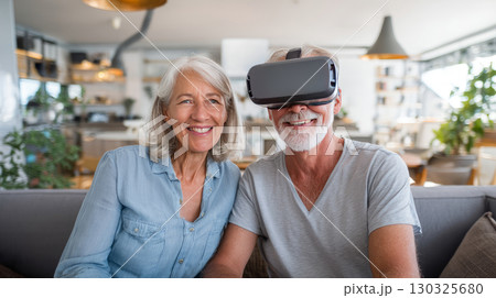 VR, gaming and metaverse with a senior couple playing a video game in their home for fun together. 3d, virtual reality and internet with an elderly gamer and his wife enjoying an immersive experience 130325680