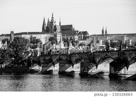 Picturesque skyline features Prague Castle towering above the historic Charles Bridge, while the Vltava River reflects their grandeur under a clear sky with no people around. Picturesque skyline features Prague Castle towering above the historic Charles Bridge, while the Vltava River reflects their grandeur under a clear sky with no people around. 130326063