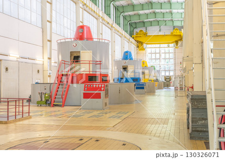The interior of Orlik Hydroelectric Power Station showcases large turbines and generators in a spacious facility. 130326071