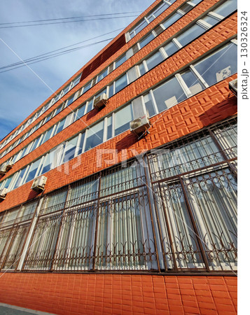 Close-up of a historic red brick facade featuring decorative window grilles for added safety and style. This image highlights building protection and urban design. Close-up of a historic red brick facade featuring decorative window grilles for added safety and style. This image highlights building protection and urban design. 130326324