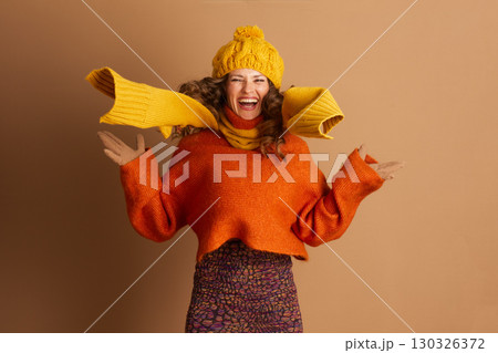 Energetic Woman Mid-Jump in Vibrant Autumn-Winter Wear Energetic Woman Mid-Jump in Vibrant Autumn-Winter Wear 130326372