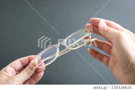 Woman holding eyeglasses. 130326620