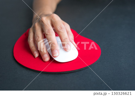 Woman hand clicking on mouse, resting her wrist on wrist rest. 130326621