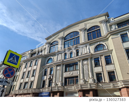 historical pink building with multiple floors, adorned with decorative features and air conditioning units on its windows. The combination of classic design and modern amenities highlights urban historical pink building with multiple floors, adorned with decorative features and air conditioning units on its windows. The combination of classic design and modern amenities highlights urban 130327383