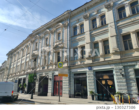 bright yellow facade with tall windows and a central archway entrance, adorned with classical decorative elements. This image captures the timeless beauty of classical architecture in a modern urban 130327386