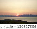 水平線に昇る朝日とオレンジ色の朝焼け空 130327556