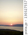 海から昇る朝日と山並みのシルエット 130327557