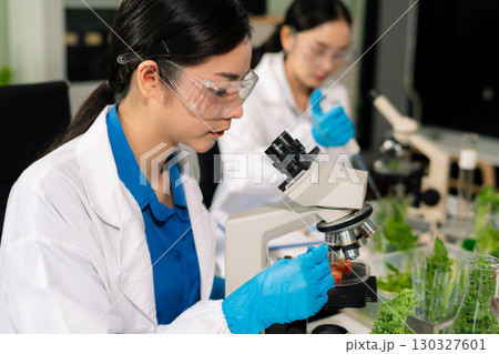 Team microbiologists and nutrition experts analyze molecular samples in advanced food science labs. 130327601