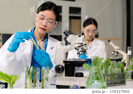 Team microbiologists and nutrition experts analyze molecular samples in advanced food science labs. 130327602