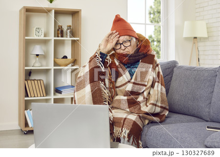 Sick senior man sitting on sofa at home and having online video call at home. Sick senior man sitting on sofa at home and having online video call at home. 130327689