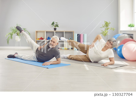 Active happy senior sporty people doing easy exercise practicing yoga lesson in gym, doing fitness Active happy senior sporty people doing easy exercise practicing yoga lesson in gym, doing fitness 130327704