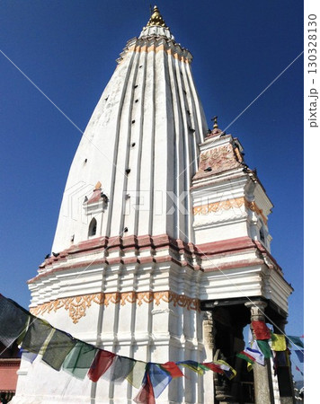 Shikhar style temple at Swayambhunath, Kathmandu, Nepal. White temple decorated with buddhist prayer flags. Shikhar style temple at Swayambhunath, Kathmandu, Nepal. White temple decorated with buddhist prayer flags. 130328130