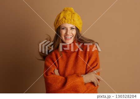 Vibrant Woman in Cable Knit Beanie and Orange Sweater 130328204