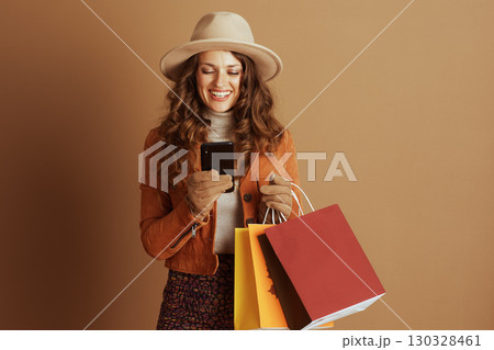 Woman Checking Phone After Autumn Shopping Woman Checking Phone After Autumn Shopping 130328461