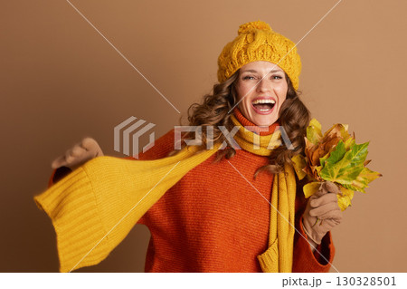Cheerful Woman in Turtleneck Laughing with Fall Leaves 130328501
