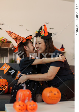 Halloween love. A mother and daughter sharing a warm hug amidst Halloween decorations. 130330137