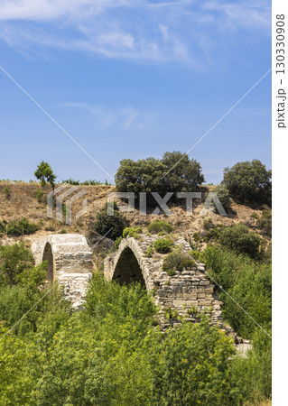 Ancient roman bridge located in Lanciego, Basque Country, Spain, connecting vineyards under blue sky Ancient roman bridge located in Lanciego, Basque Country, Spain, connecting vineyards under blue sky 130330908