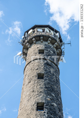 Svatobor lookout tower stands tall with its rugged stone structure and communication equipment. Clear skies enhance the scenic view, inviting visitors to explore the surroundings. Svatobor lookout tower stands tall with its rugged stone structure and communication equipment. Clear skies enhance the scenic view, inviting visitors to explore the surroundings. 130331262