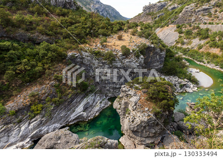 Elevated view of a canyon with a calm, emerald green river 130333494