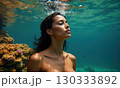Woman swims underwater in coral sea or ocean 130333892
