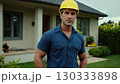 Man in yellow helmet standing in front of the house. He's wearing uniform and he's construction 130333898
