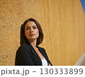 Woman model with long hair stands on concrete wall background 130333899