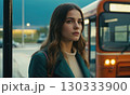 Young woman is standing at the city bus stop 130333900